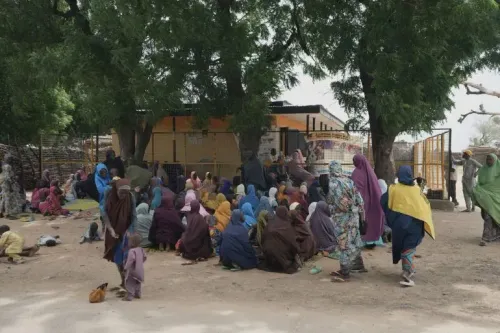 مجموعة من الأشخاص يرتدون ملابس ملونة يجلسون تحت الأشجار في شمال نيجيريا، في سياق أزمة الجوع الشديدة.