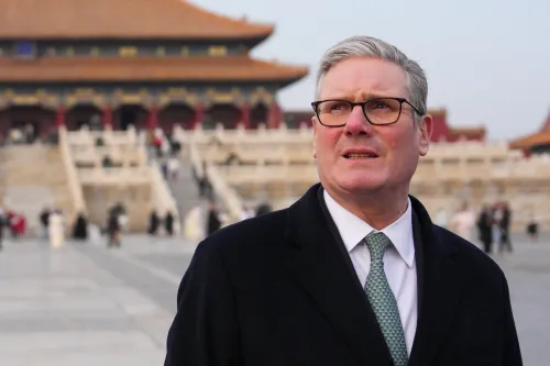 كير ستارمر، زعيم حزب العمال البريطاني، يتجول في موقع تاريخي بالصين، مع خلفية معمارية تقليدية وزوار آخرين.