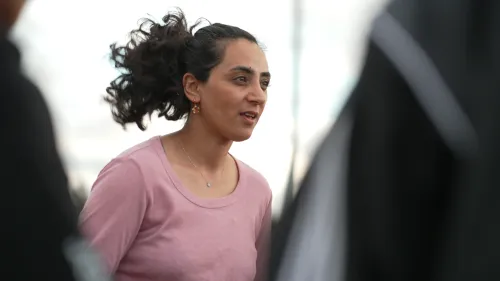 شابة أفغانية تتحدث بقلق أثناء تدريب فريق اللاجئات الأفغانيات، تعكس مشاعر الأمل والتحدي في ظل الظروف الصعبة.