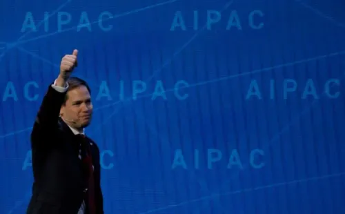رجل يرفع إبهامه بإيجابية أمام خلفية تحمل شعار AIPAC، في سياق مناقشة تأثير جماعات الضغط على السياسة الأمريكية.