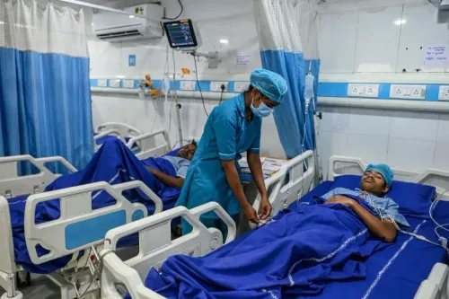 مريض يتلقى العلاج في مستشفى بعد الانفجار في مصنع SIGC.NS، حيث يظهر ممارس صحي يقوم بفحص حالته وسط أجواء طبية.