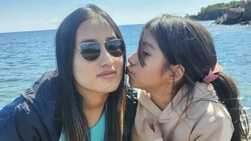 صورة تظهر إليزابيث زونا كايساغوانو البالغة من العمر 10 سنوات مع والدتها، بينما يستمتعون بوقت معًا على شاطئ، تعبيرًا عن الروابط الأسرية في ظل الظروف الصعبة.