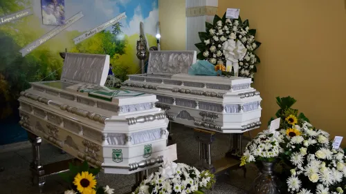 توابيت بيضاء مزينة بالزهور، تُعرض في مكان مخصص للتعازي في كولومبيا، تمثل تذكيرًا بأعمال العنف الأخيرة في شمال البلاد.