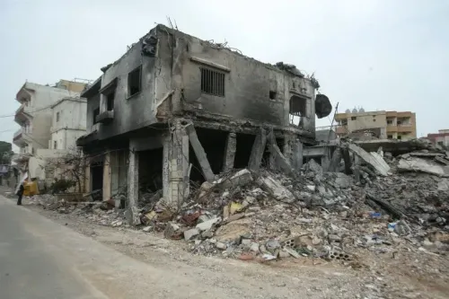 مبنى مدمر في قرية آت-تيري بجنوب لبنان، يظهر آثار الغارات الإسرائيلية، مع أنقاض وحطام في محيطه، مما يعكس الأوضاع المتدهورة في المنطقة.