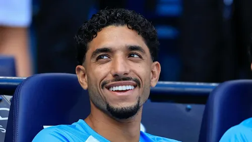 عمر مرموش مبتسم يرتدي قميص مانشستر سيتي، استعدادًا لأول مباراة له مع توتنهام هوتسبر في الدوري الإنجليزي الممتاز.