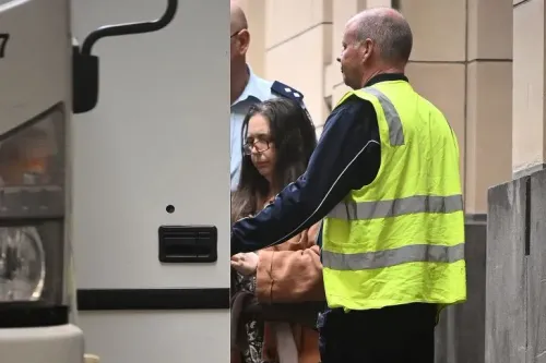 امرأة محاطة برجال أمن، تغادر المحكمة بعد الحكم عليها بالسجن مدى الحياة بتهمة قتل ثلاثة من أقارب زوجها بالفطر السام.