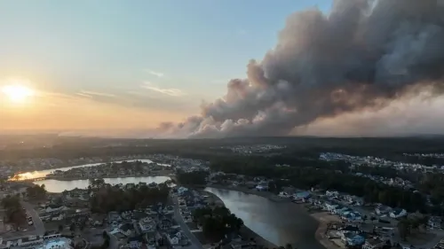 دخان كثيف يتصاعد فوق منطقة سكنية في كارولينا الجنوبية، مع غروب الشمس في الأفق، نتيجة حريق غابات كبير بالقرب من ميرتل بيتش.