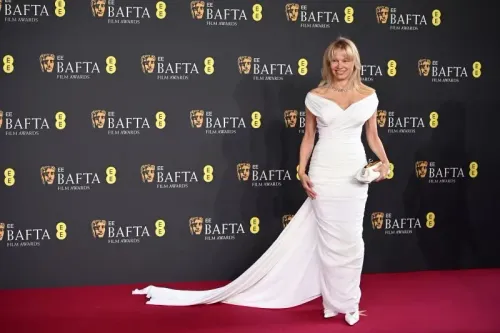 ممثلة ترتدي فستانًا أبيض أنيقًا مع ذيل طويل، تقف على السجادة الحمراء خلال حفل جوائز BAFTA في لندن.