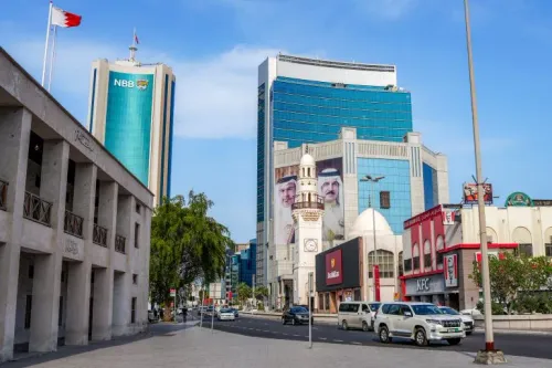 صورة لشارع حديث في البحرين يظهر فيه مباني تجارية بارزة، مع لافتات تعكس النشاط الاقتصادي، مما يعكس الوضع الاجتماعي والسياسي في البلاد.