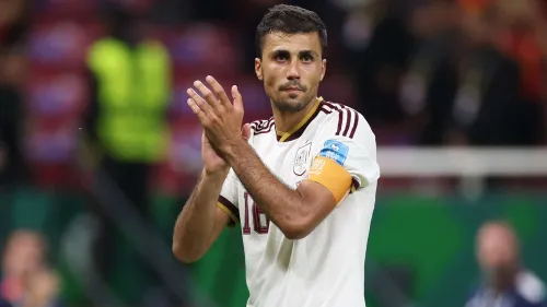 رودري لاعب وسط إسباني يصفق مرتدياً شارة القيادة مع منتخب إسبانيا، في سياق مفاوضات انتقاله بين برشلونة ومانشستر سيتي.
