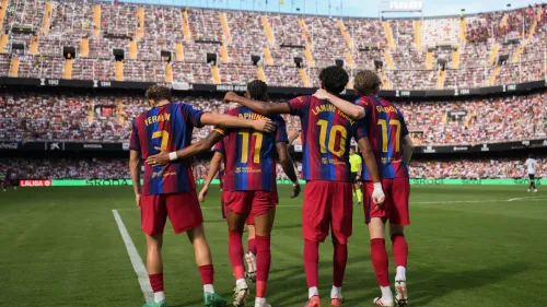 لاعبو برشلونة يحتفلون معًا في ملعب كامب نو خلال مباراة الدوري الإسباني، مع التركيز على التعاون والتمريرات الحاسمة لأنتوني جوردون.