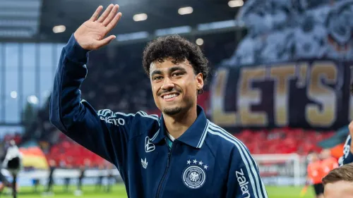 ناثانييل براون، المدافع الألماني الأمريكي، يلوح مبتسمًا مرتديًا زي منتخب ألمانيا استعدادًا لموسم جديد مع بايرن ميونيخ.