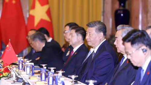 اجتماع رسمي في الصين مع مسؤولين حكوميين، يتوسطهم الرئيس شي جين بينغ، مع وجود الأعلام الصينية في الخلفية.