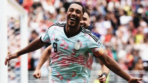 لاعب كرة قدم بلجيكي يحتفل بهدفه في مباراة مثيرة ضد السنغال ضمن كأس العالم، مرتدياً قميص المنتخب البلجيكي.