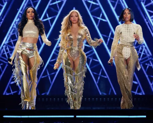 ثلاث فنانات يرتدين أزياء ذهبية، بيونسيه وميشيل ويليامز وكيلي رولاند، يتألقن على المسرح خلال عرضهن في لاس فيغاس.