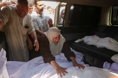 نساء ورجال يعبّرون عن حزنهم أمام جثث ضحايا القصف الإسرائيلي على مدرسة في جباليا، حيث سقط العديد من القتلى والجرحى.