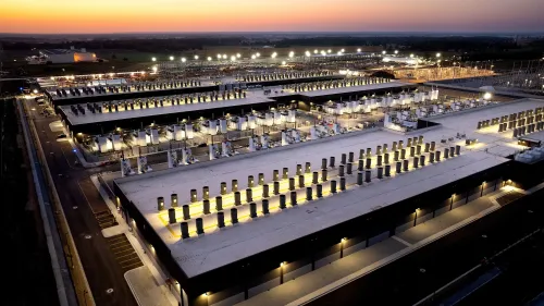 مركز بيانات كبير مضاء في المساء مع صفوف من المعدات الكهربائية، يعكس تأثير أزمة الكهرباء على الفواتير في الولايات المتحدة.