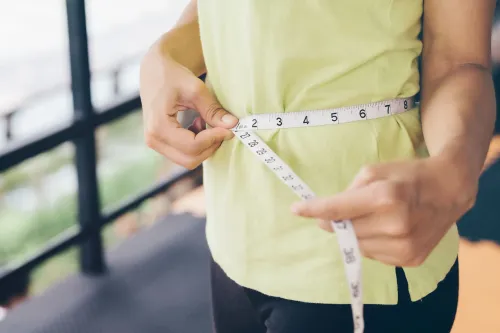 شخص يقيس محيط خصره بشريط قياس، مما يعكس أهمية مراقبة محيط الخصر لتقييم مخاطر الصحة لدى كبار السن.