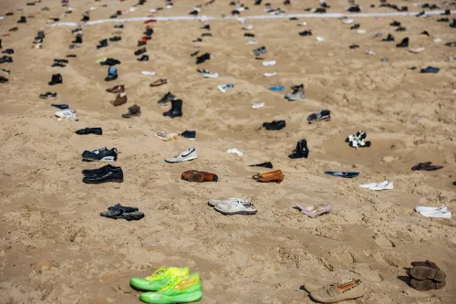 أحذية متروكة مبعثرة على شاطئ في شمال فرنسا، في إشارة إلى محاولات عبور المهاجرين القناة الإنجليزية.