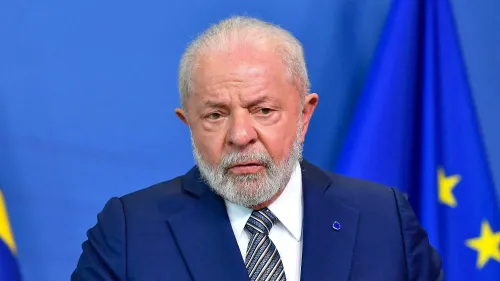 رجل ذو لحية وشعر رمادي، يبدو عابساً، يقف أمام خلفية زرقاء مع أعلام. يعكس الصورة التوترات السياسية في البرازيل بعد اعتقال جايير بولسونارو.