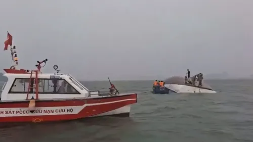 قارب سياحي مقلوب في خليج ها لونغ، مع فرق إنقاذ تعمل على استعادة الركاب المفقودين بعد انقلاب القارب بسبب عاصفة.