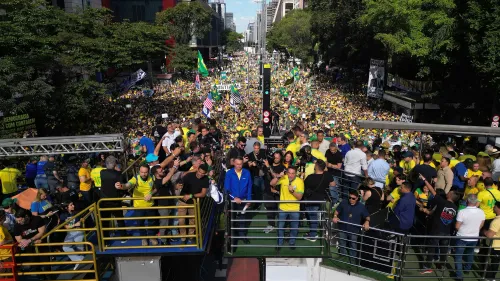 تجمع حشود كبيرة في ساو باولو احتجاجًا على محاكمة جايير بولسونارو، مع لافتات وأعلام تعبر عن مطالب للحرية والعدالة.