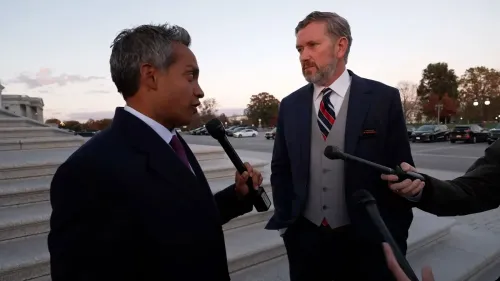 مقابلة صحفية خارج مبنى الكونغرس، حيث يتحدث رجلان يرتديان بدلات، مع وجود صحفيين ومعدات تصوير حولهما.