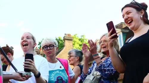 نساء يبتسمن ويحتفلن في تجمع لدعم حقوق الإجهاض، مع لافتة تحمل عبارة "حقوق الإجهاض"، تعبيرًا عن تأييدهن للتغييرات القانونية في المملكة المتحدة.