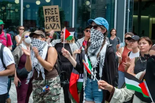محتجون يحملون أعلام فلسطين ولافتة تطالب بتحرير غزة، خلال مظاهرة تضامنية في مدينة بريطانية، تعبيراً عن دعمهم للقضية الفلسطينية.