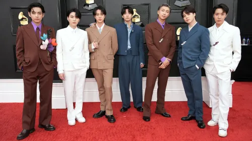 فرقة BTS تتألق في حفل توزيع الجوائز، حيث يظهر الأعضاء ببدلات أنيقة ملونة. تعكس الصورة عودتهم المرتقبة إلى الساحة الموسيقية.