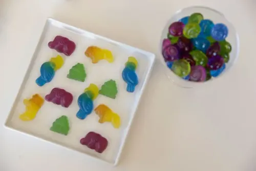 حلوى ملونة بأشكال حيوانات وأشجار، تمثل تحولًا نحو استخدام الأصباغ الطبيعية في المنتجات الغذائية.