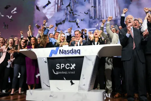 احتفال فريق SpaceX في Nasdaq بعد الاكتتاب العام، حيث يرفعون أيديهم في الفرح وسط قصاصات ورقية، مع شعار الشركة واضحاً.