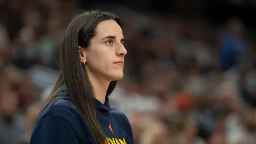 كيتلين كلارك، نجمة كرة السلة، تتابع مباراة فريقها إنديانا فيفر من المدرجات، معبرة عن أهمية تحسين أجور الرياضيين في الدوري.