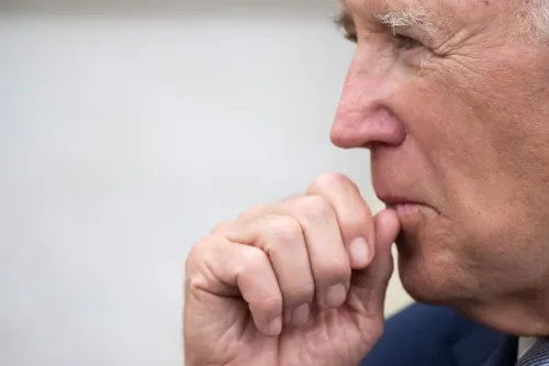 صورة تُظهر جانب وجه الرئيس بايدن وهو يضع إصبعه على شفتيه، مما يعكس تفكيرًا عميقًا حول قرارات العفو المثيرة للجدل.