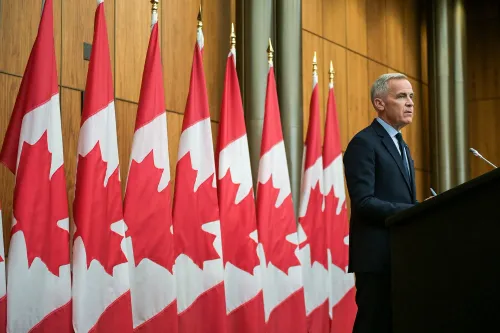 مارك كارني يتحدث أمام مجموعة من الأعلام الكندية، في سياق اجتماعات مع ترامب حول التحديات الاقتصادية والتعريفات الجمركية.