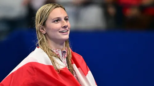 سمر ماكينتوش، السباحة الكندية، مبتسمة وتحمل علم كندا بعد تحطيمها الرقم القياسي العالمي في سباق 400 متر حرة بزمن 3:54.18.