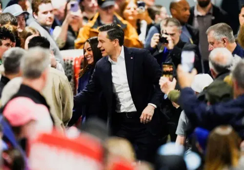 حشد كبير من أنصار حزب المحافظين خلال حملة انتخابية، حيث يظهر بيير بويليفر وهو يتفاعل مع الحضور في أجواء حماسية.