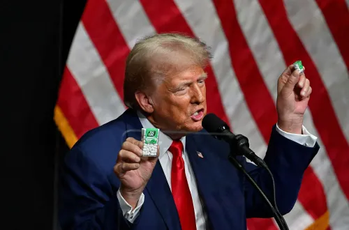 ترامب يتحدث في تجمع حاشد، ممسكًا بعلبة حلوى تيك تاك، مشيرًا إلى التضخم وتأثيره على القدرة على تحمل التكاليف.