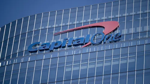 شعار شركة كابيتال وان على واجهة مبنى زجاجي، يعكس تأثير مشكلة تقنية مع بائع خارجي على خدمات البنك.