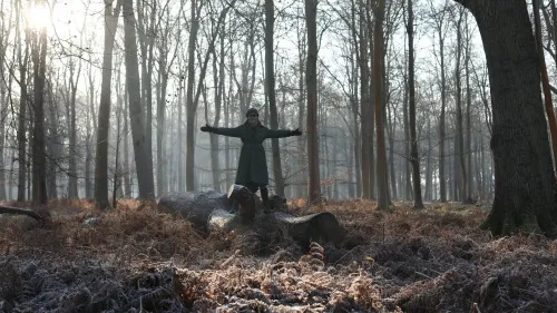 أميرة ويلز كاثرين تحتضن الطبيعة في غابة، مبتسمةً احتفالاً باليوم العالمي للسرطان، مع إشارة للتعافي والأمل.