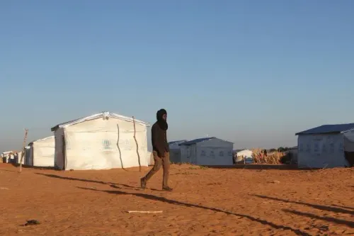 شخص يسير في مخيم للاجئين في شرق تشاد، حيث تزايدت أعداد النازحين بسبب النزاع في السودان.