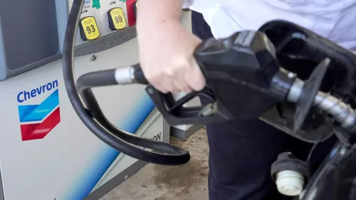 شخص يعبئ الوقود في محطة شيفرون، مما يعكس أهمية الصفقة الكبرى لشيفرون مع شركة هيس في قطاع النفط.