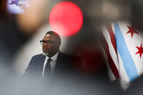 عمدة شيكاغو براندون جونسون يجلس في مؤتمر صحفي، مع ظهور علم المدينة خلفه، أثناء مناقشة خطط لمقاومة سياسات الهجرة الفيدرالية.