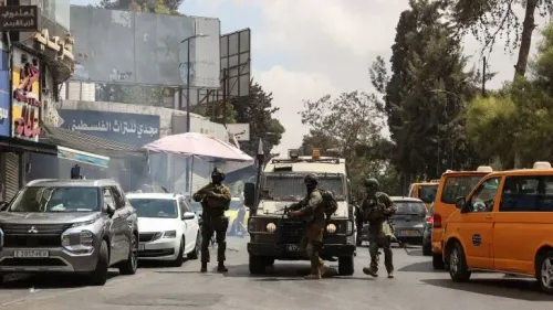 جنود إسرائيليون يتواجدون في وسط مدينة رام الله، مع وجود مركبات مدنية في الخلفية، خلال غارة عسكرية على المنطقة.