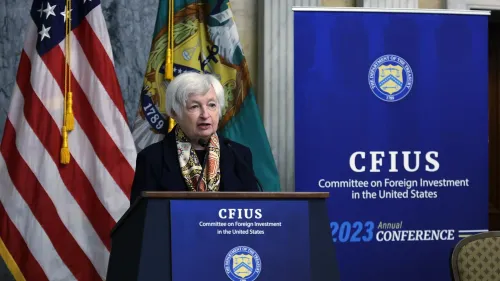 وزيرة الخزانة جانيت يلين تتحدث في مؤتمر لجنة الاستثمار الأجنبي في الولايات المتحدة (CFIUS) 2023، مع العلم الأمريكي خلفها.