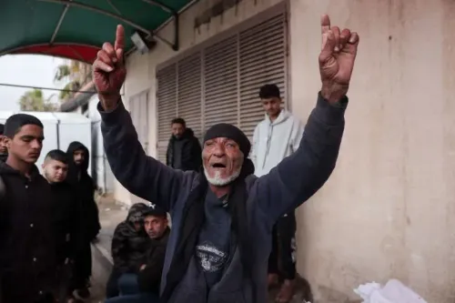 رجل مسن يرفع يده في إشارة، محاط بمجموعة من الشباب، في مشهد يعكس الأجواء المشحونة في غزة بعد الاشتباكات الأخيرة.