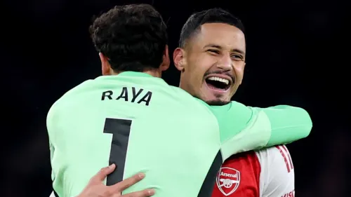 ديفيد رايا حارس مرمى أرسنال يحتفل مع زميله، مع التركيز على أدائه الموثوق وجوائزه المتتالية في الدوري الإنجليزي الممتاز.
