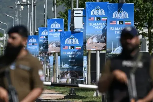 لافتات تحمل شعار "محادثات إسلام آباد" باللغات الإنجليزية والفارسية والألمانية، مع وجود عناصر أمنية في المقدمة.