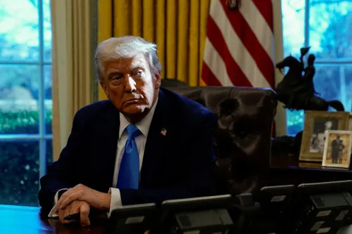 ترامب يجلس في المكتب البيضاوي، مع تعبير وجهه الجاد، محاطًا بأعلام أمريكية وصور عائلية، يعكس مشاعر القلق حول أداءه الاقتصادي.