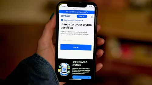 شاشة هاتف تعرض تطبيق Coinbase مع عبارة "ابدأ محفظتك الرقمية" وواجهة تسجيل دخول، تعكس التوجه نحو تنظيم العملات الرقمية.